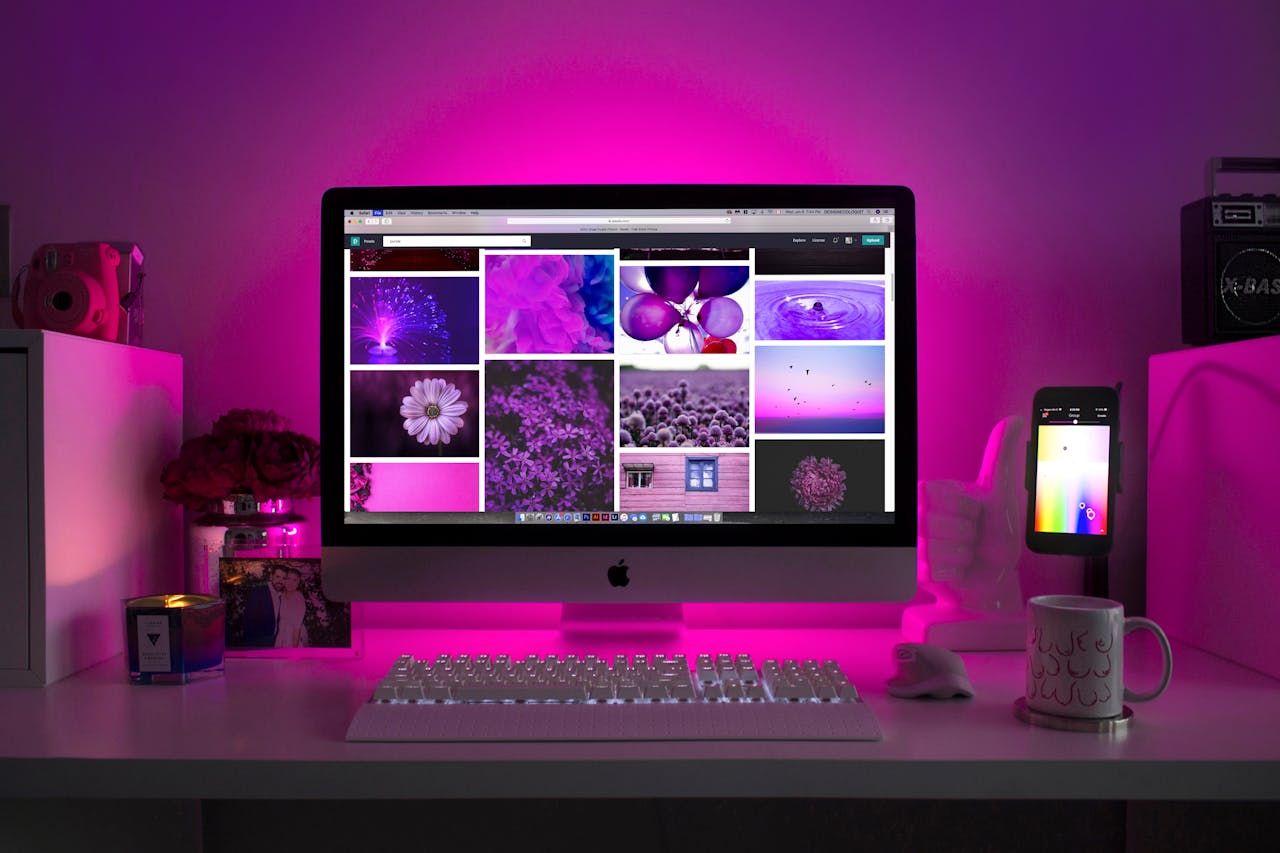 home-img Modern desk setup with neon lighting and a desktop computer displaying colorful images.