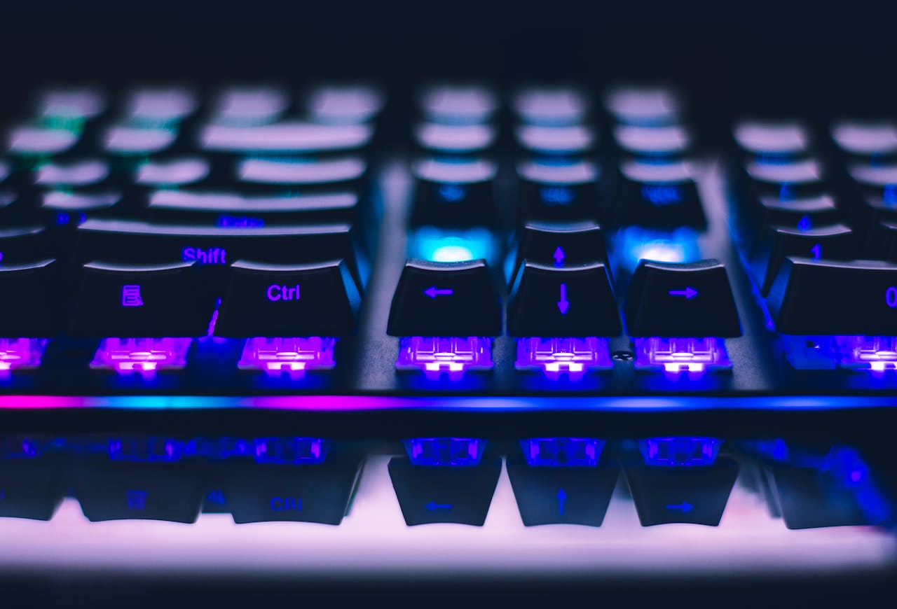 about-img-01 A detailed close-up of illuminated mechanical keyboard keys with focus on blue and purple lights.