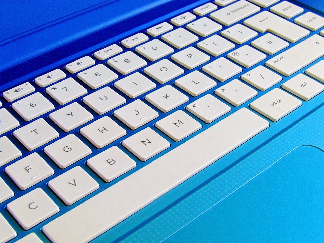 about-img Detailed close-up image of a white computer keyboard on a blue laptop.
